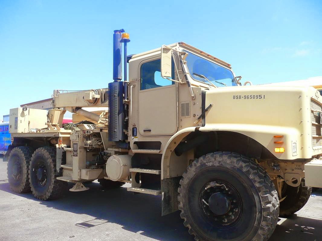 Desert tan heavy 6x6 truck with a crane-equipped flatbed, finished in a uniform tan
